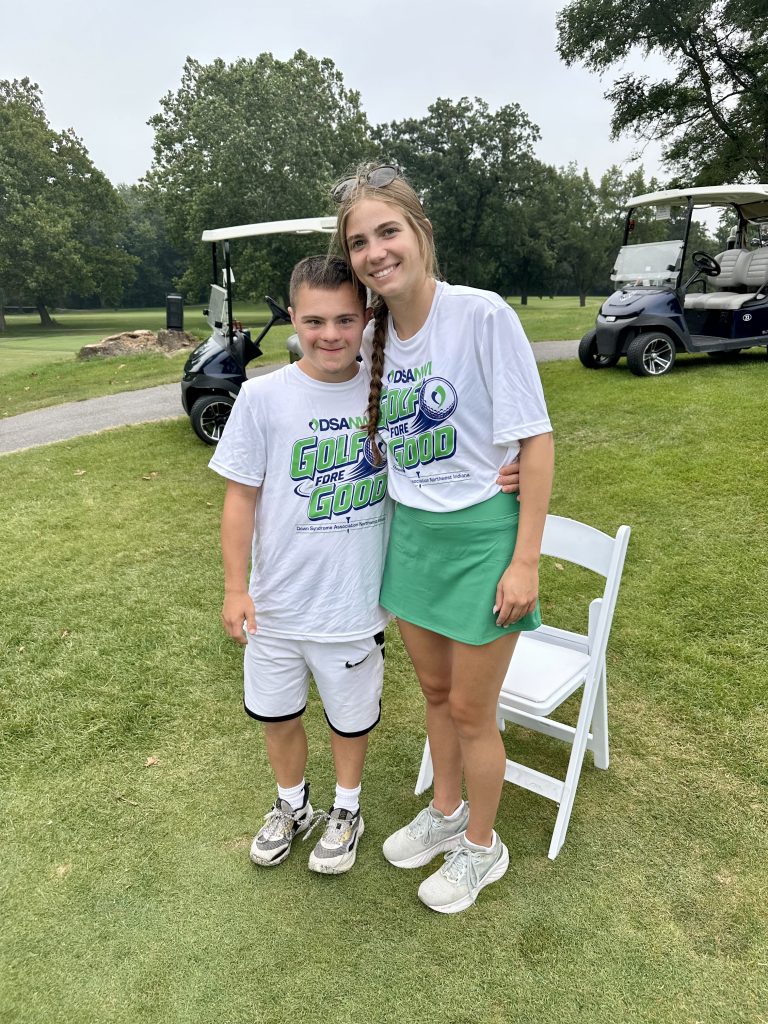 A young girl and a volunteer on the course at Golf Fore Good
