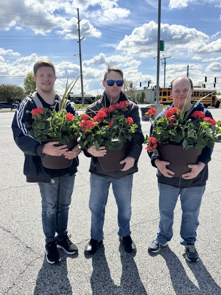 Three young adults delivering flowers during a DSANWI fundraiser