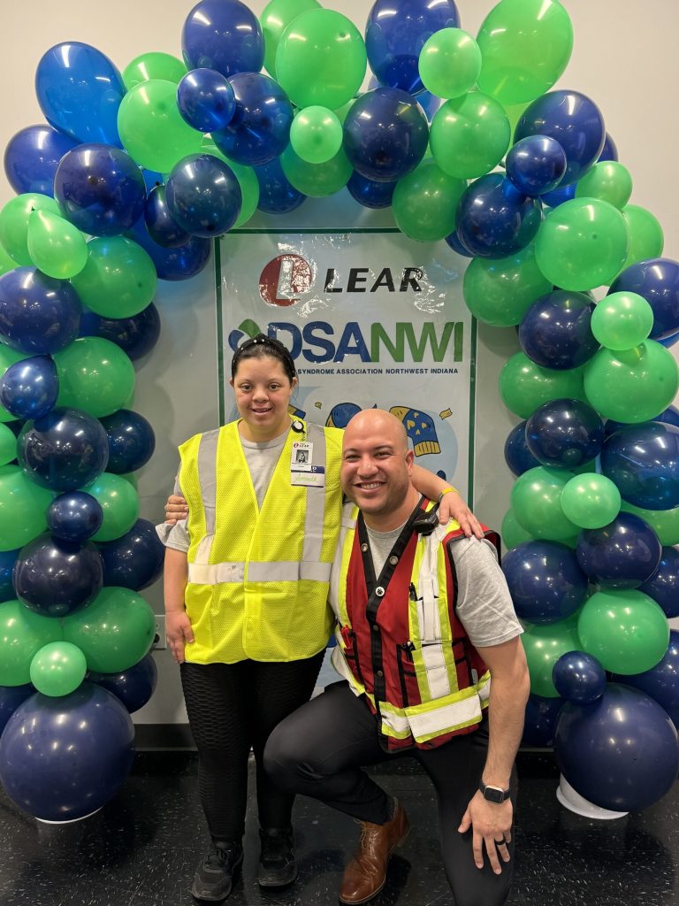 Volunteers under a DSANWI and Lear Corporation balloon arch at a corporate sponsor event